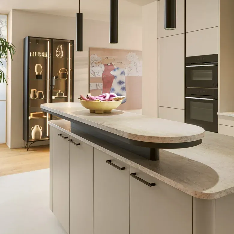 Moderne Inselküche in Beige matt mit zweistufiger Naturstein-Arbeitsplatte und Barboard-Funktion